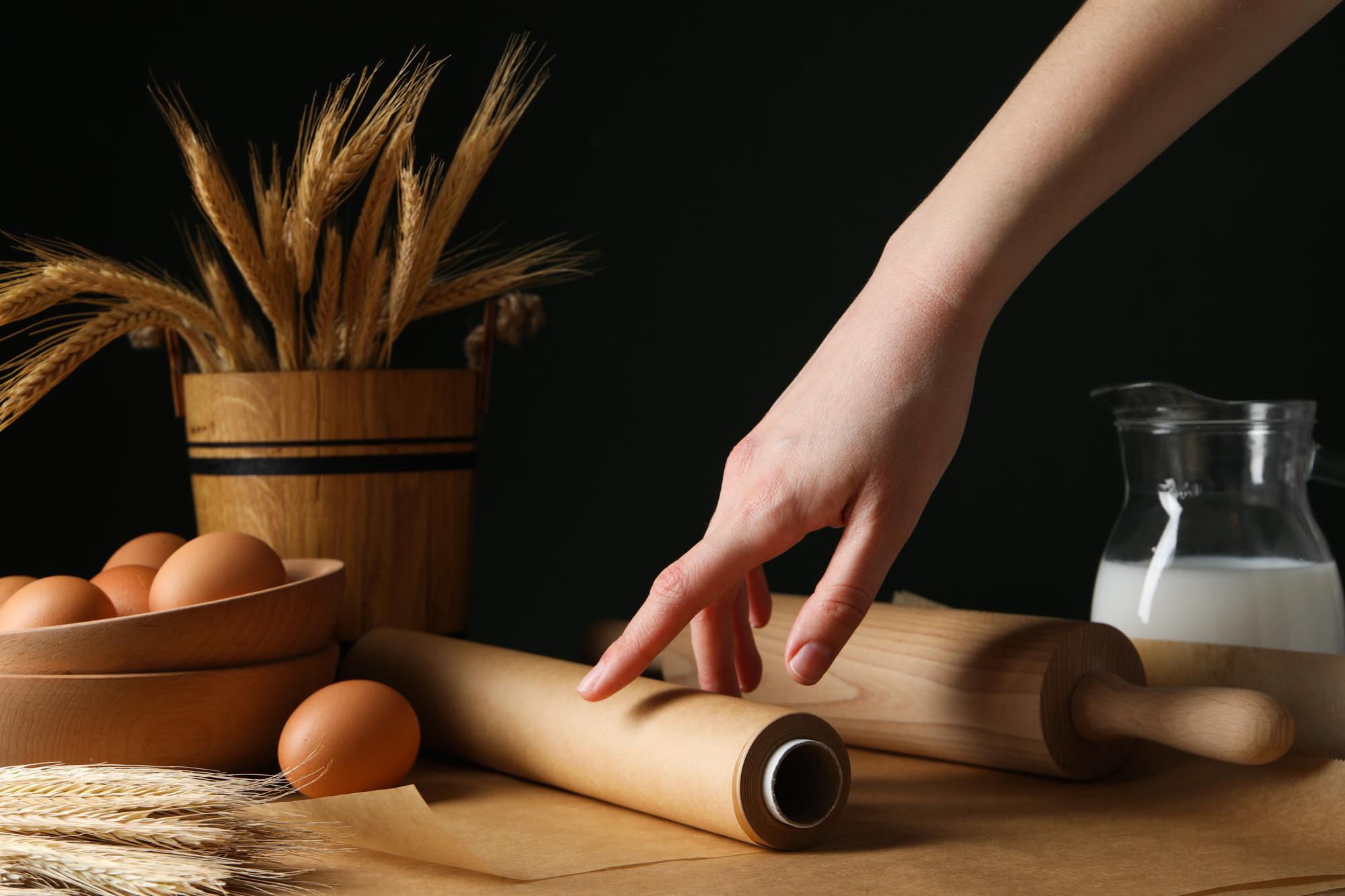 Hands preparing dough with flour and rolling pin